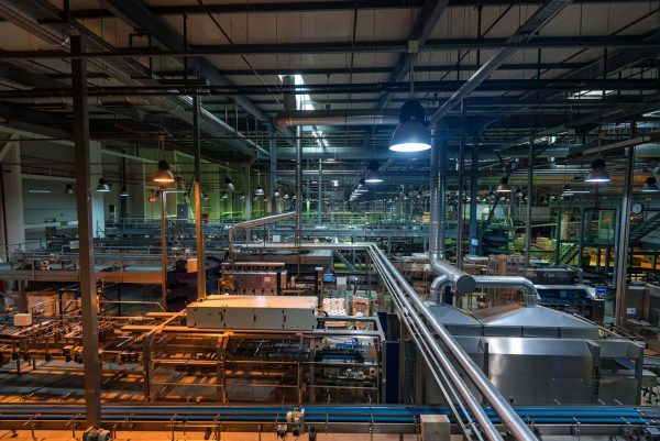 Food and beverage manufacturing facility with industrial processing lines, conveyor systems, and stainless steel piping